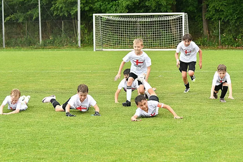 Das ging natürlich gut bei dem nassen Rasen: Die Engländer bejubeln ihren 2:1-Sieg gegen Kanada im Halbfinale standesgemäß mit e