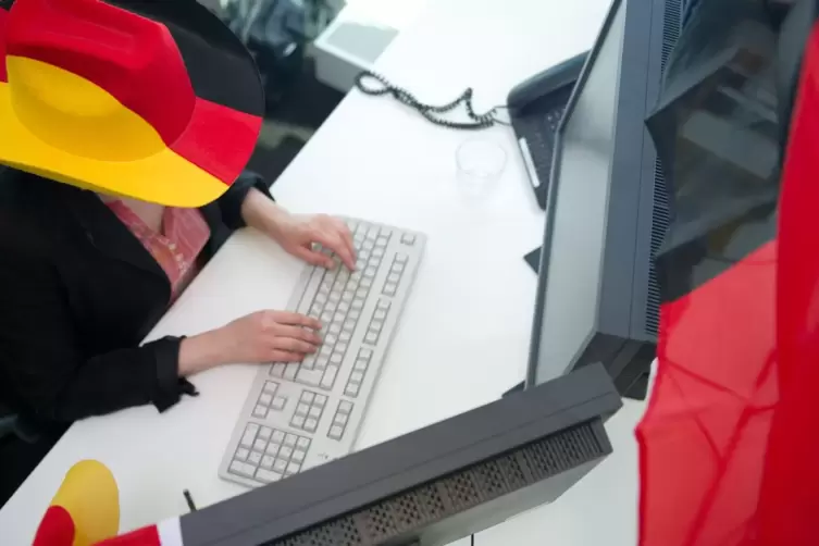 Eine Frau in Fankleidung am Arbeitsplatz