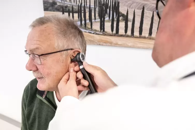 Ein Arzt untersucht einen Patienten mit einem Otoskop