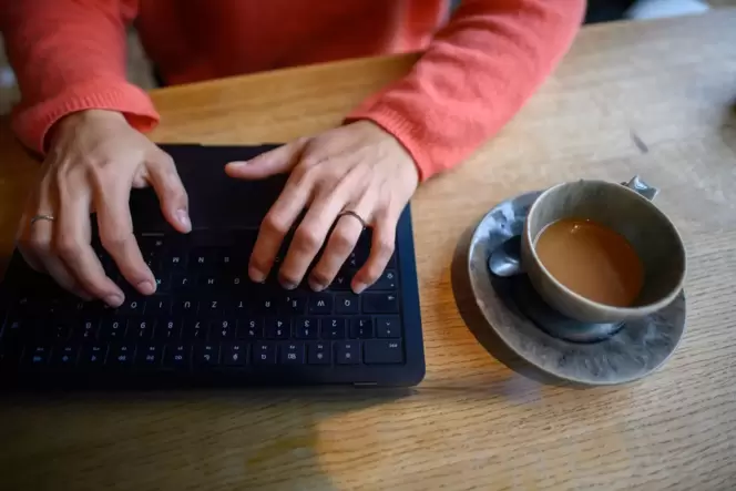 Eine Frau nutzt ihren Laptop in einem Café