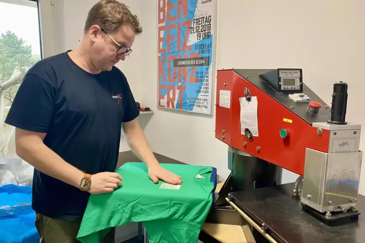 An der Textilpresse: Fabian Schumm beim Bedrucken eines T-Shirts. 