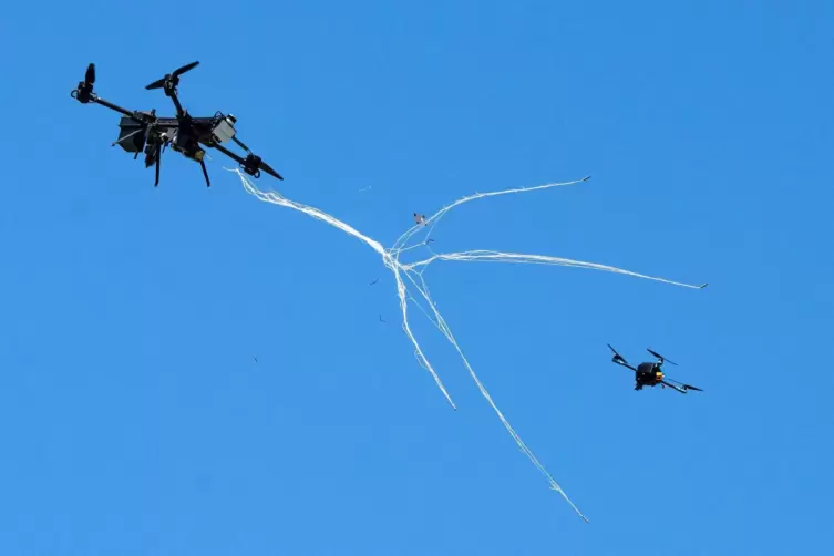 Eine Drohne von Argus Interception f&auml;ngt eine kleine Drohne mit einem Netz. 