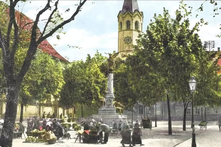 Wochenmarktst&auml;nde, gruppiert um das Kriegerdenkmal vor dem Rathaus. Kolorierte Ansichtskarte aus den 1920er-Jahren.