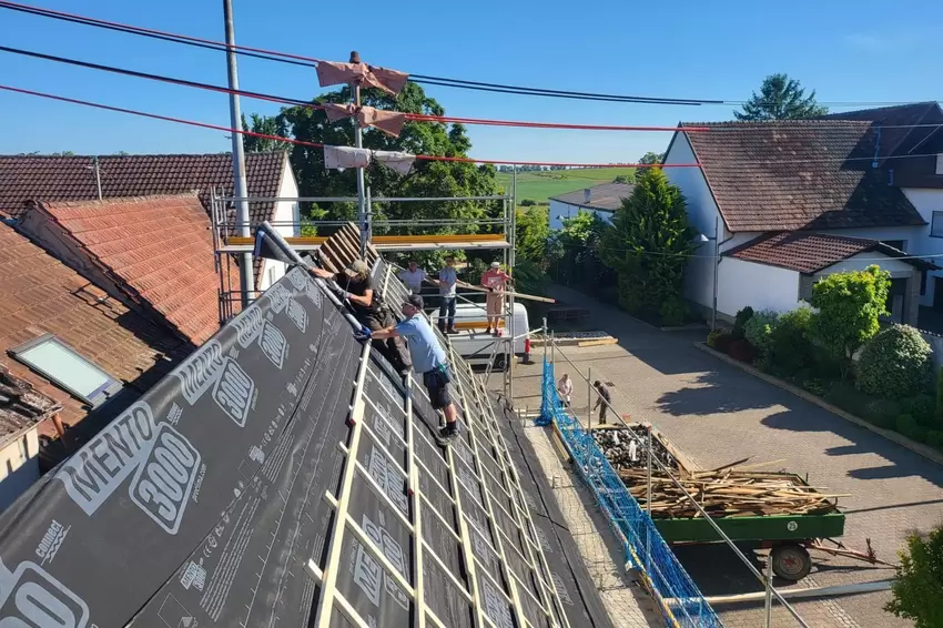 Wie genau ein Dach professionell neu gedeckt wird, hat ein Dachdecker aus Duttweiler den Helfern vom Förderverein gezeigt.
