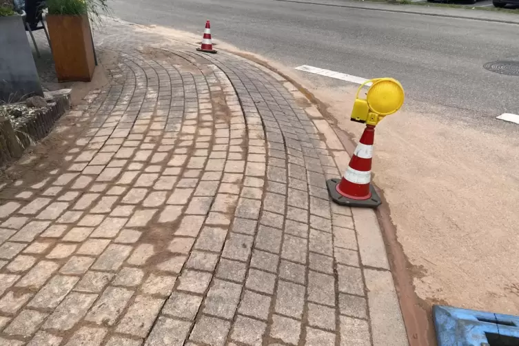 Der ausgeschwemmte Feinsand setzte sich unter dem Gehweg fest, die Pflastersteine w&ouml;lbten sich mehrere Zentimeter hoch, Sand wur