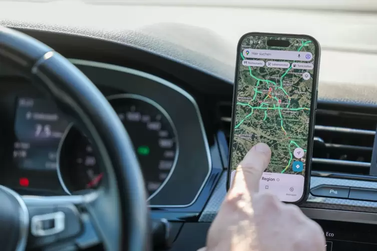Ein Mann nutzt ein Smartphone im Auto