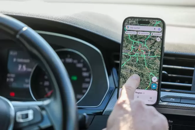 Ein Mann nutzt ein Smartphone im Auto