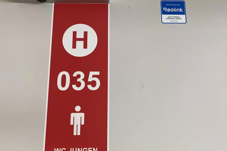 Ein Aufkleber auf der T&uuml;r zur Jungentoilette weist auf die Video&uuml;berwachung hin. 