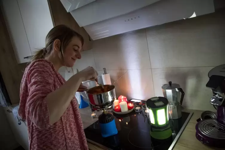 Eine Frau kocht mit einem Fondue-Set eine Mahlzeit