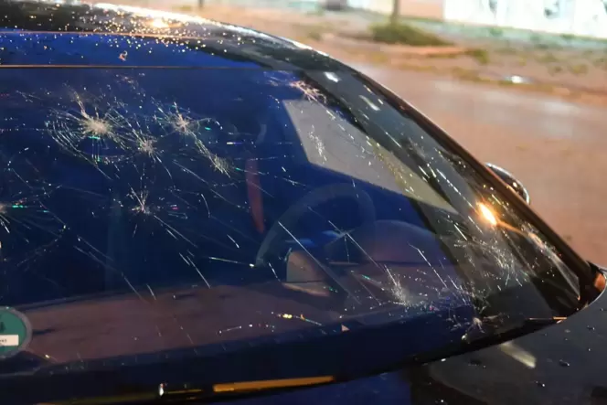 Eine durch Hagel beschädigte Frontscheibe eines Autos
