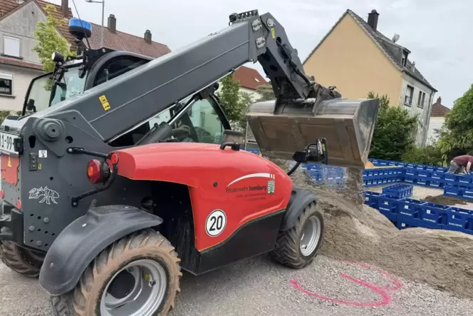 Ein kleiner Bagger schüttet Sand am Erbacher Sportzentrum auf, wo mehr als 10.000 Getränkekisten zu einem Labyrinth gestapelt we