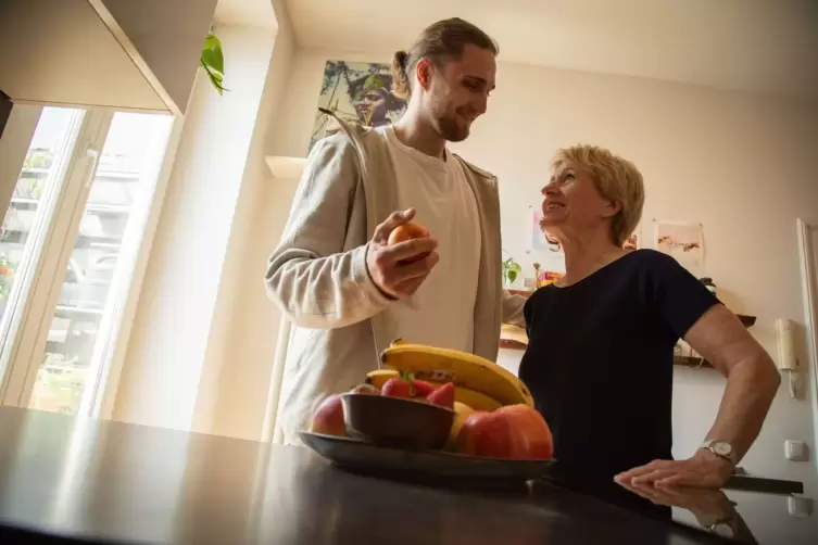 Ein junger Mann hilft einer älteren Frau in der Küche