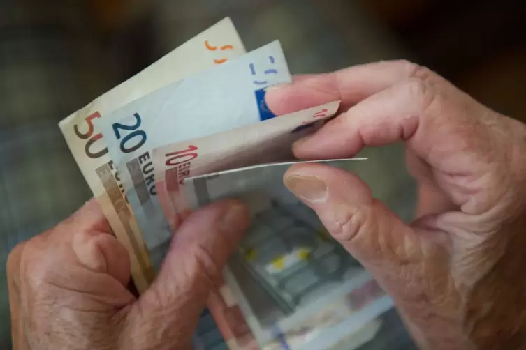 Eine Seniorin z&auml;hlt Geldscheine