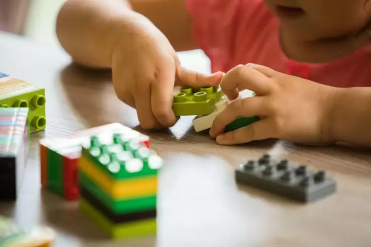 Ein M&auml;dchen spielt mit Klemmbausteinen