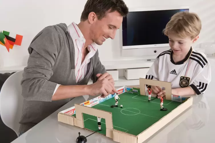 Vater und Sohn spielen mit dem selbstgebastelten Tischkicker