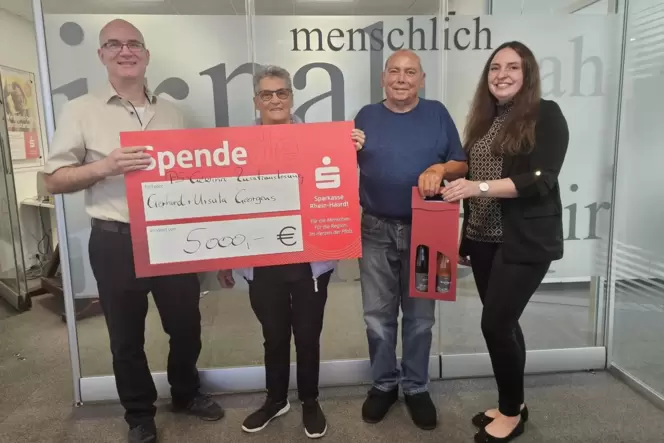Janina Heck und Florian Buscher übergeben dem Ehepaar Georgens (Mitte) den Gewinn über 5000 Euro.