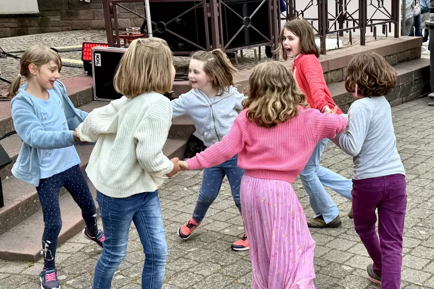Die Kinder tanzen vor der Bühne zur Musik.