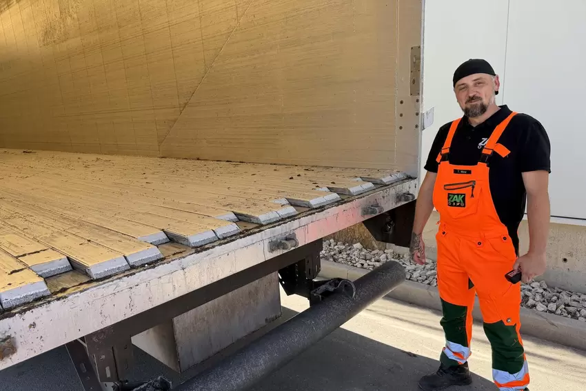 Thorsten Wetz steuert mit der Fernbedienung den Walking Floor seines Elektro-Sattelschleppers.