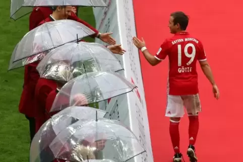 Mario Götze klatscht auf dem Weg zur Übergabe der Meisterschale die ehemaligen Meister-Spieler des FC Bayern München ab.