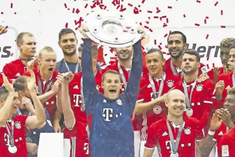 FC-Bayern-Torwart Manuel Neuer reckt die Meisterschale in die Höhe.