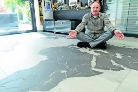 Walter Schmitt in seinem Reisenraum – mit Weltkarte als Fußbodenmosaik. 