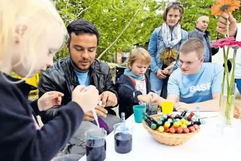 Malen mit Farben und Pipette: BASF-Azubi Enes Günes zeigt Mira (links) und Emilia mit seinem Kollegen Justin Münzenberger, wie e