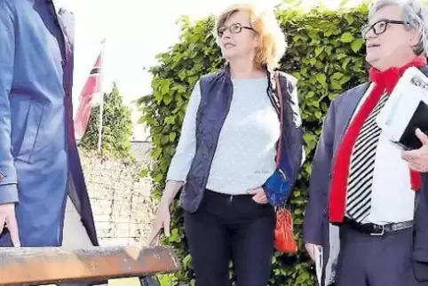 Verbandsbürgermeister Uwe Schwind (rechts) und der Bundestagsabgeordnete Thomas Hitschler bekommen von Linda Colling die kaputte