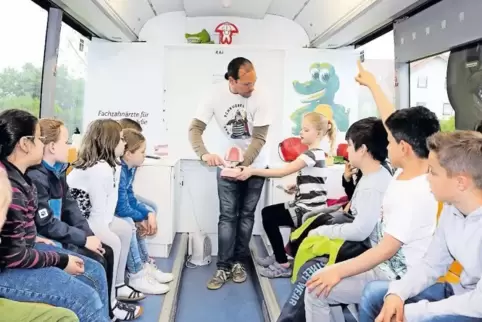 Blick in den Zahnpflegebus: Matthias Heil und Schüler.