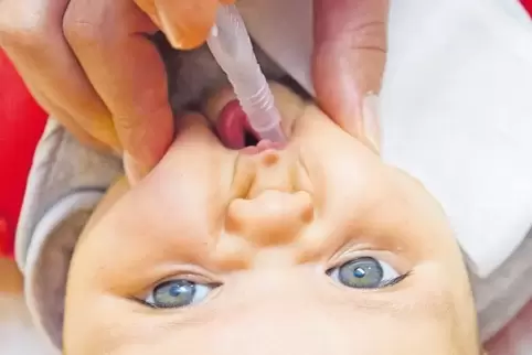 Ein drei Monate altes Baby bekommt eine Schluckimpfung.