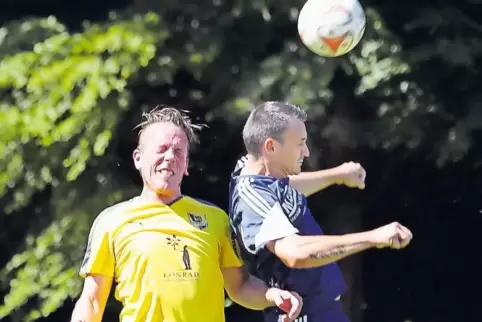 Dominik Schmalz (in Gelb, SV Erlenbach) und der Herxheimer Cristian Cenusa gehen ins Kopfballduell.