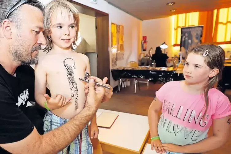 Beim &bdquo;Paintbrushing&ldquo; f&uuml;r Kinder wird das Motiv quasi aufgepustet. Philip und Leile sind von der Kunst von Oliver Dominik begeist