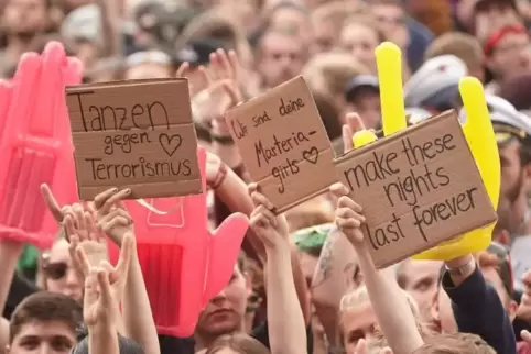 Besucher des Musikfestivals „Rock am Ring“ halten vor der Bühne Schilder gegen Terrorismus hoch. Foto: dpa 