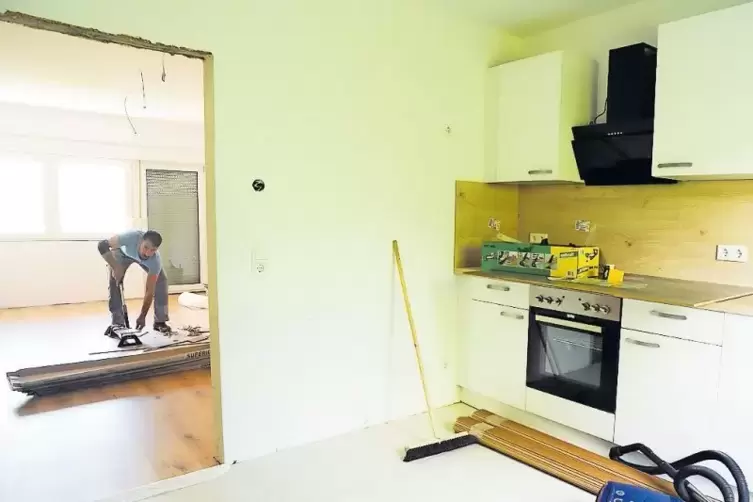 Die K&uuml;chenzeilen mit Herd und K&uuml;hlschrank sind schon eingebaut, auf dem Boden wird Eichenlaminat verlegt.