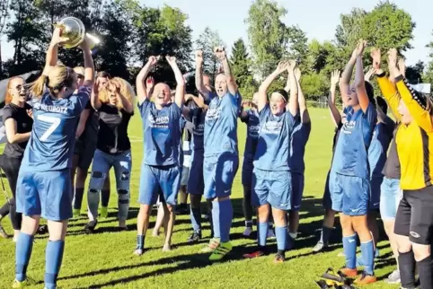 Theresa Lösch, Kapitän der SG Neupotz, hält den Pokal hoch.