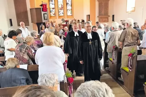 Voll besetzte Kirchenbänke: Kirchenpräsident Schad vor Pfarrer Thomas Kessler und Gemeindereferent Andreas Werle.