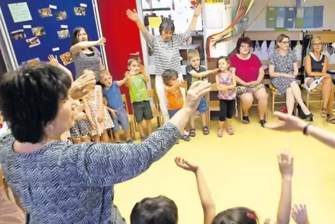 Mit einem bunten Programm aus Spielen und Liedern zeigen die Kinder Bildungsministerin Stefanie Hubig (hinten, Zweite von rechts