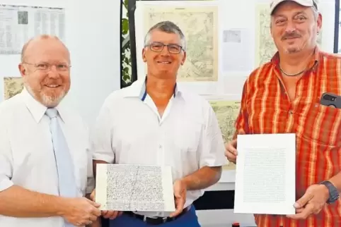 Die historische Urkunde in den Händen: Der Ortsbürgermeister von Winnweiler, Rudolf Jacob, Ortsvorsteher Ullrich Schmitt und Lot