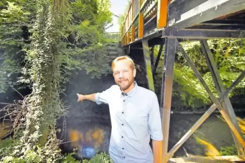 Oben die Kussbrücke, unten das trübe Gewässer: Florian Benner zeigt auf den Gießhübelbach.
