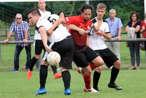 Manchmal ist Fußball ein Ringen: FV Berghausen (rotes Trikot) gegen VfL Neustadt. Foto: Lenz 