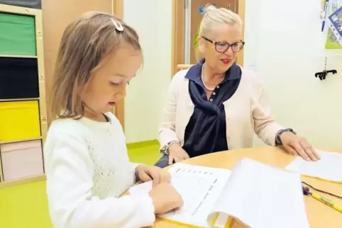 Die vierjährige Milena, an diesem Morgen das erste Kind, „hilft“ Leiterin Sigrid Schmenger bei ihren morgendlichen Bürotätigkeit