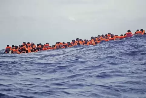 Hoffen auf Hilfe: Etwa 15 Kilometer vor der libyschen Küste warteten am Dienstag Flüchtlinge darauf, von Mitgliedern einer Nicht