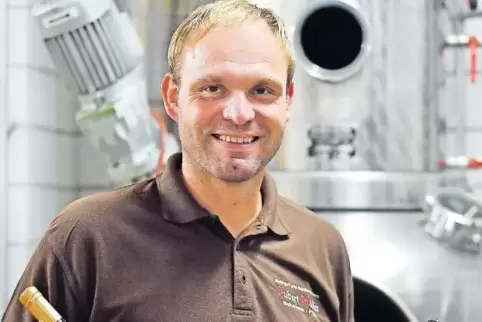 Stefan Müller mit einem Premium-Tresterbrand aus Gewürztraminer (links) und einem Gin vor seiner Brennblase.