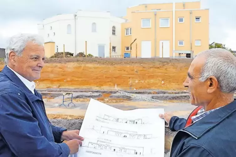 Rolf Kirsch (links) und Salih Yavas vor dem Grundstück mit dem Bauplan.