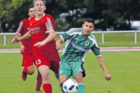 Yasin Özcelik (rechts) hebt den Ball aus 30 Meter Entfernung über Winnweilers Torwart Paul Robin Assel. Eric Iselborn (links) ko