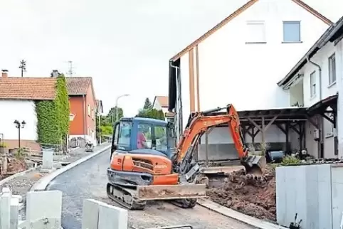 Nachdem die erste Asphaltschicht aufgebracht ist, folgen die Arbeiten am Gehweg.