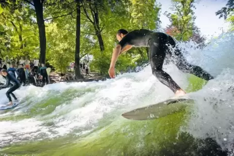 Surfer am Eisbach in München: Mithilfe einer speziellen Konstruktion entsteht eine dauerhafte Welle.