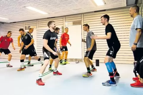 VTZ-Trainer Danijel Grgic (rechts) beobachtet seine Mannschaft beim Stretching-Programm vor dem eigentlichen Handball-Training.