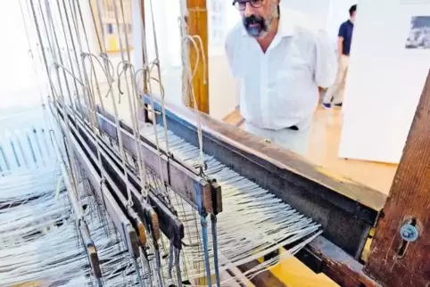 Ausstellungsbesucher Daniel Jablonsky begutachtet interessiert den ausgestellten, alten Webstuhl.