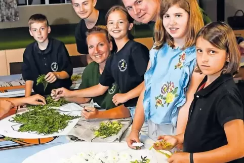 Wiederentdeckter Brauch: Kinder vom Theaterkreis und vom Vogelpark Bobenheim-Roxheim bereiten die Motive für den Blumenteppich v