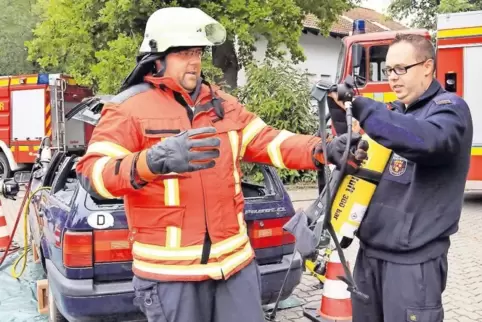Einmal Feuerwehrmann sein: Stefan Roth probiert die Einsatzkleidung an. Feuerwehrmann Christopher Mauer hilft dabei.